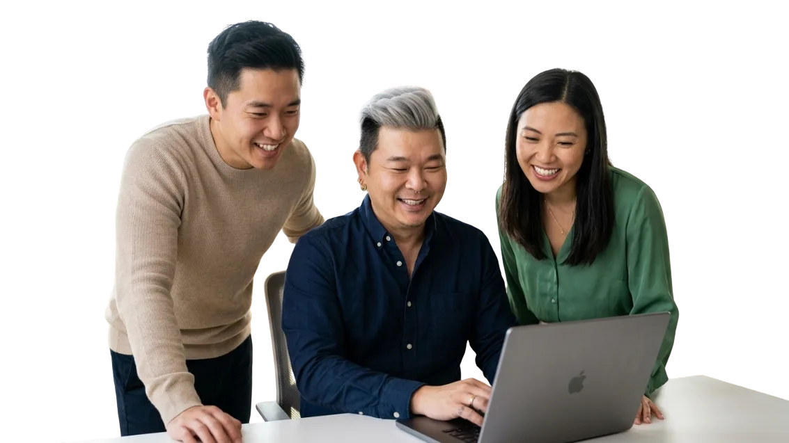 Desmond working on a laptop with two colleagues